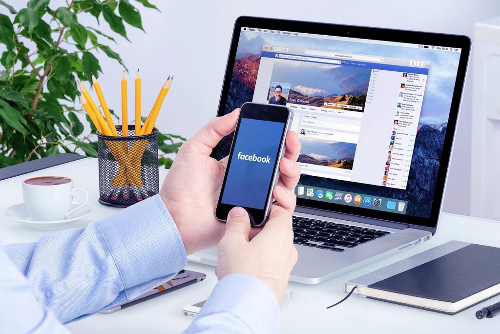 Facebook en el celular y en la laptop, midiendo campañas de Meta